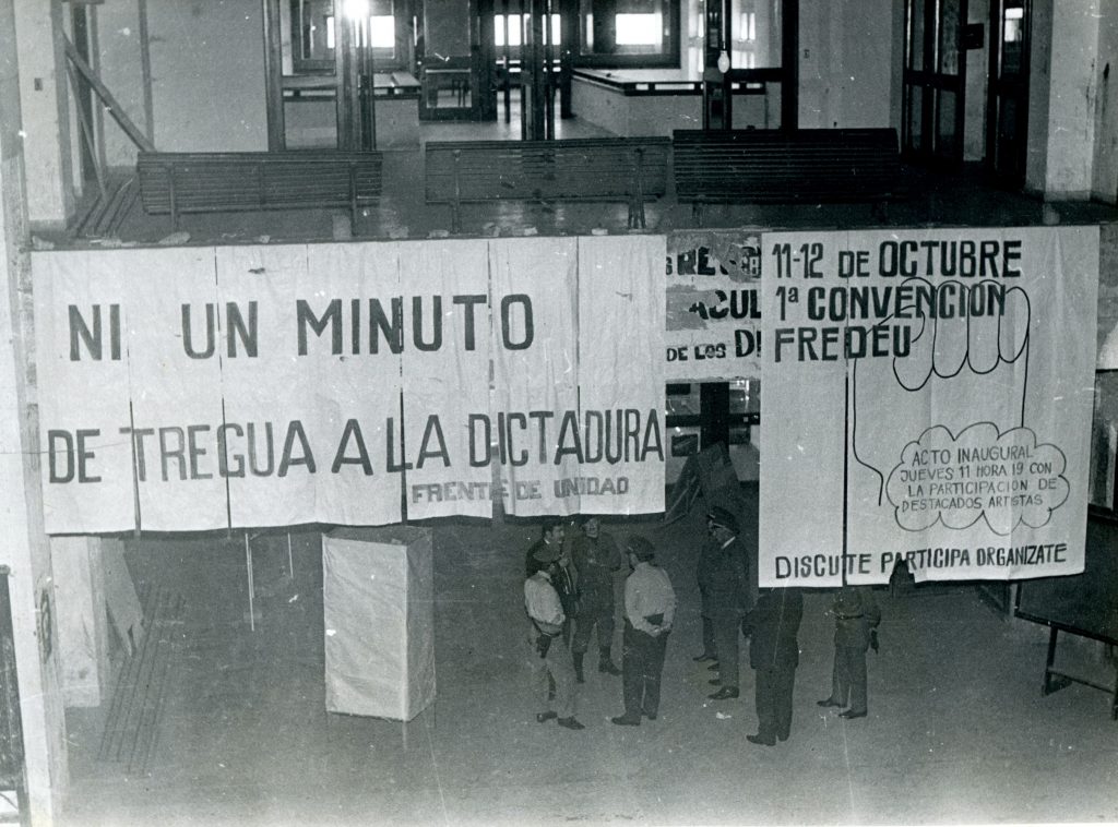 Miembros del ejército debajo de carteles de protesta durante la intervención de la UdelaR.